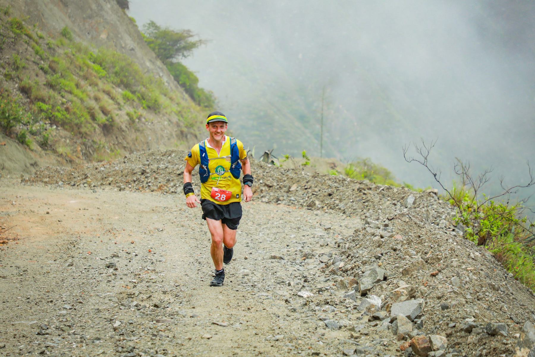 Trail runner on an Ecuador mountain road in fog